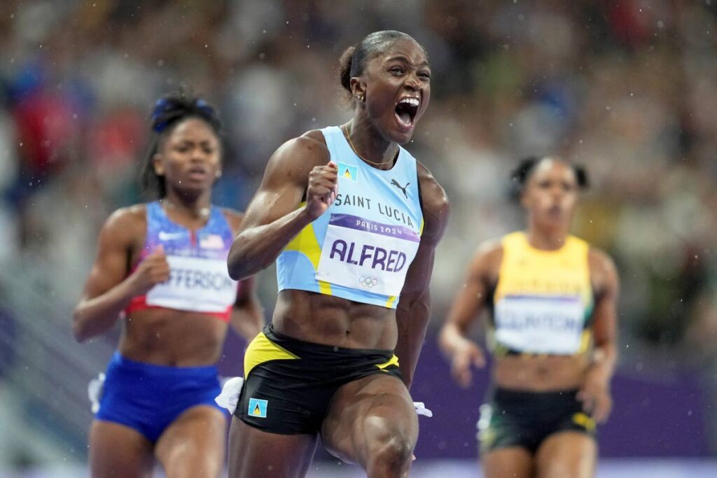 Julien Alfred, of Saint Lucia, celebrates after winning the gold medal in the women's 100 meters final at the 2024 Summer Olympics, Saturday, Aug. 3, 2024, in Saint-Denis, France. - AP PHOTO/Ashley Landis