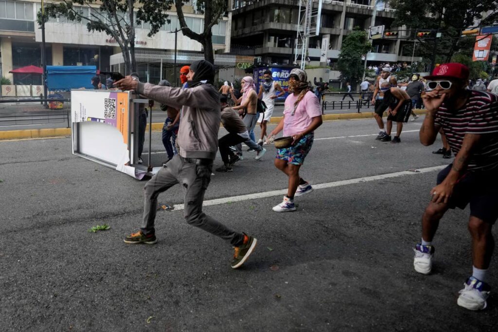 A protester aims a weapon during clashes with police during demonstrations against the official election results declaring President Nicolas Maduro's reelection in Caracas, Venezuela, on July 29. AP PHOTO - 