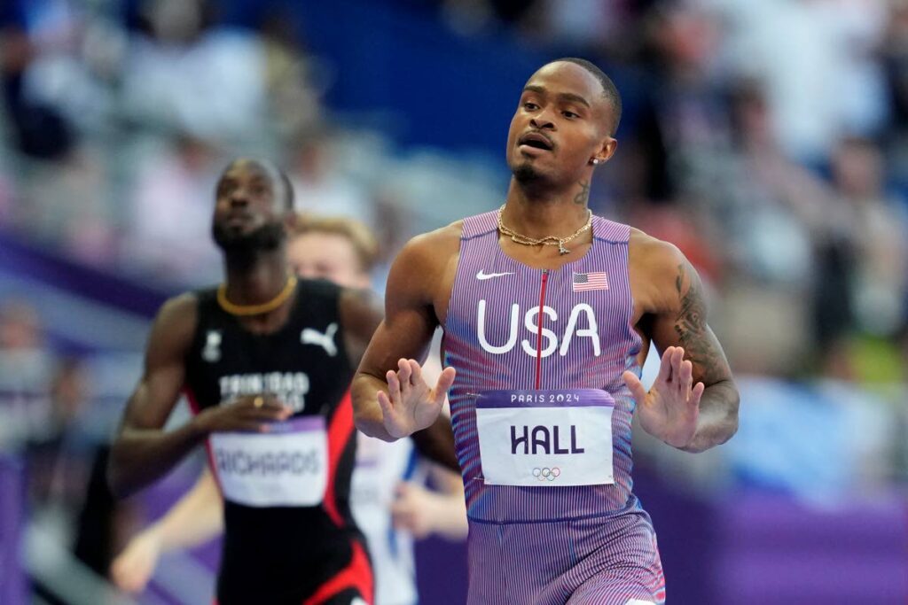 Quincy Hall, of the United States, gestures after crossing the finish line ahead of Jereem Richards, of Trinidad and Tobago, left, in a men's 400 metres semifinal at the 2024 Paris Olympics, on Tuesday, August 6, 2024, in Saint-Denis, France - AP PHOTO