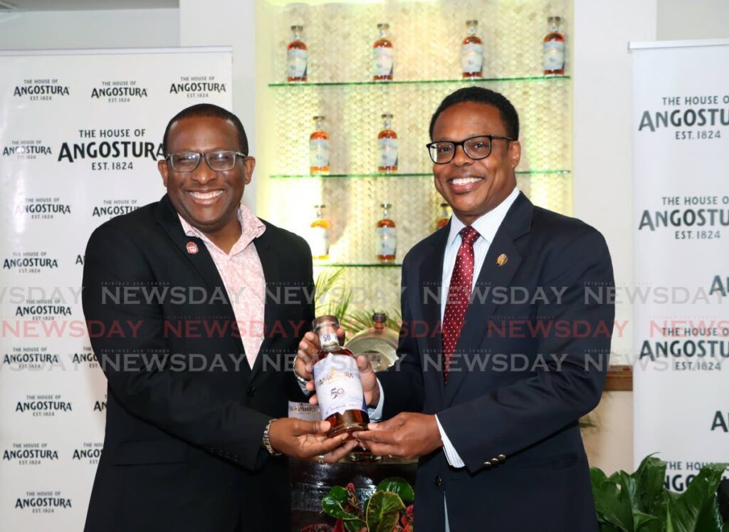 Angostura chief operating officer Ian Forbes, left, presents Minister of Foreign and Caricom Affairs Dr Amery Browne, with a bottle of Angostura Tribute during a press conference at Angostura head office in Laventille, on August 7. Angostura Tribute was developed to mark Caricom's 50th anniversary. - Photo by Venessa Mohammed