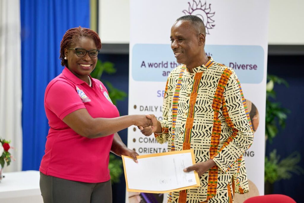 Assemblyman Dr Faith BYisrael, Secretary of Health, Wellness and Social Protection handing the deed over to Mr. Felix Cazoe, President of the Trinidad and Tobago Blind Welfare Association. - 