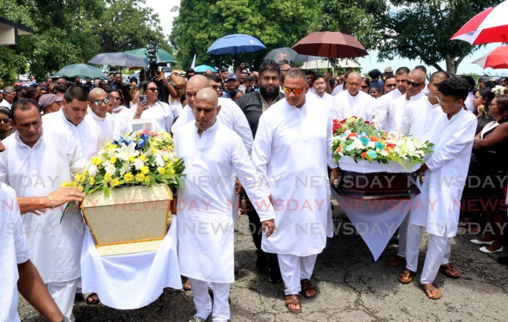 The funeral processions of Ryan Ramnanan and Sachin Teeluckdharry carry their caskets for cremation at the Shore of Peace Cremation Site at Mosquito Creek, San Fernando, on Thursday. - Photo by Roger Jacob