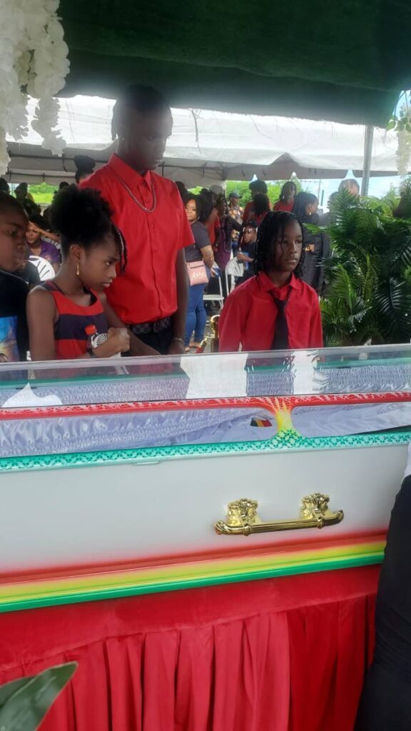 Jonathan Wharwood's three children stand at his casket during his funeral at the Sea Lots Basketball Court on August 8. Wharwood was killed in a police shooting in Sea Lots on July 23 - 