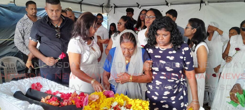 Sookdaye Doy Harripersad, 92, pays her last respects during his funeral to her son Robby Harripersad, 57, who died from dengue on August 5. - Photo by Rishard Khan