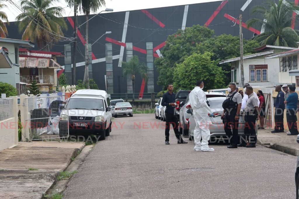 Police at the home of Roger Derry, 65, who was discovered dead in the living room of his home on Farah Street, San Fernando, on August 12. - Photo by Lincoln Holder 