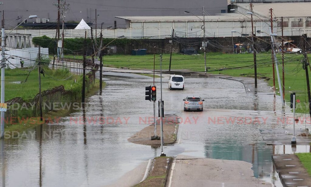 Drivers attempt to navigate floodwaters on South Quay, Port of Spain on August 12. - Photo by Roger Jacob