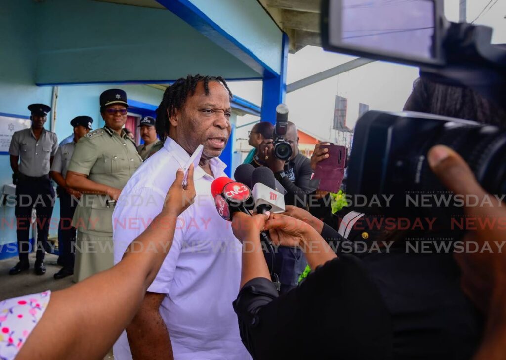 Keith Scotland, minister in the ministry of national security, talks to the media as CoP Erla Harewood-Christopher looks on in the background during a walkabout in Crown Point, Tobago on August 12. - Photo by Visual Styles