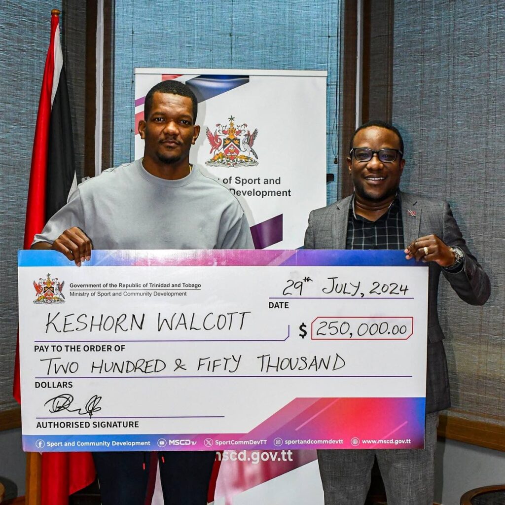 TT javelin star Keshorn Walcott, left, is presented with a $250,000 cheque by acting permanent secretary at the Ministry of Sport and Community Development, David Roberts, at the ministry's head office in Port of Spain on August 12. - Photo courtesy Ministry of Sport and Community Development