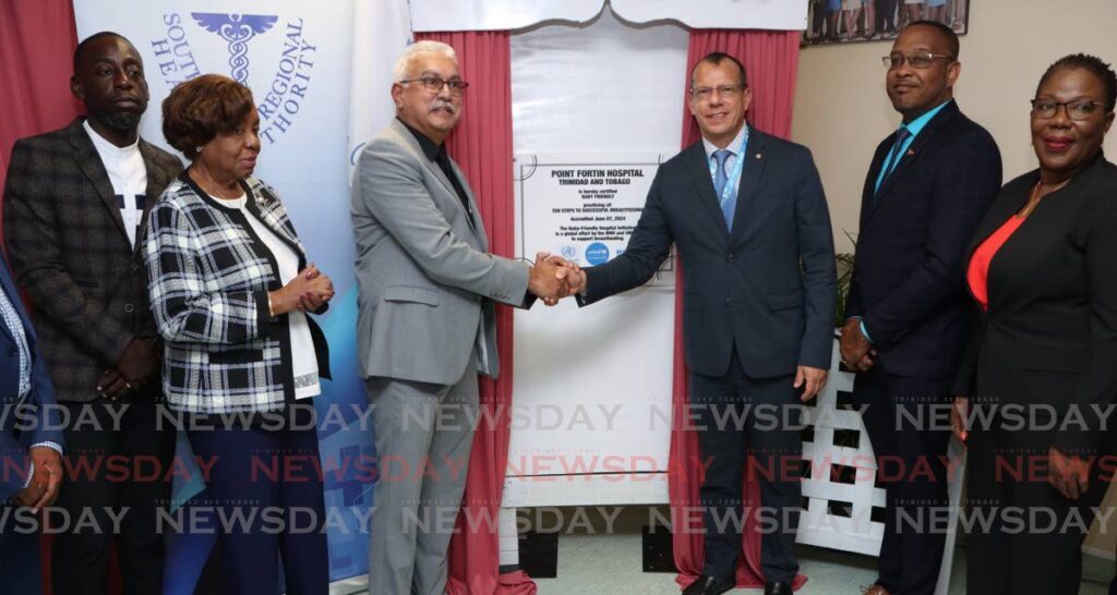 Minister of Health Terrence Deyalsingh, third from left and PAHO/WHO representative Dr Gabriel Vivas Francesconi, shake hands after revealing the Point Fortin Hospital's baby-friendly accreditation plaque at the hospital on August 14. Also in picture are, from left, Point Fortin MP Kennedy Richards Jr, chairman of the SWRHA board of directors Valerie Alleyne-Rawlins, SWRHA CEO Dr Brian Amour and Ministry of Health director of women's health Debra Thomas. - Photo by Angelo Marcelle