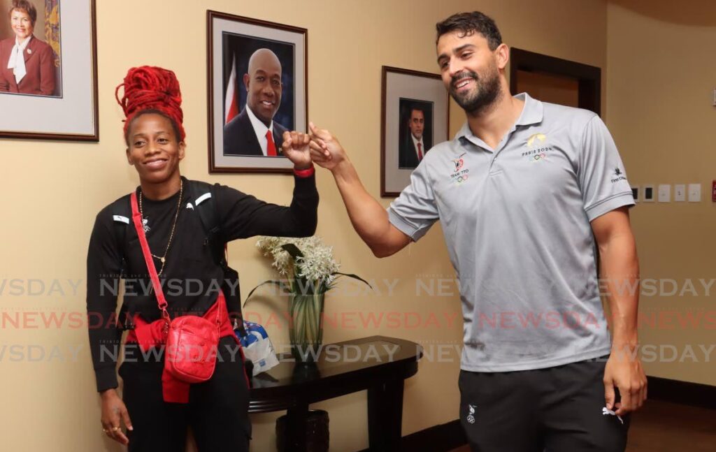 Sprinter Michelle Lee-Ahye and swimmer Dylan Carter greet each other after arriving home at the Piarco International Airport on August 14. - Photo by Faith Ayoung