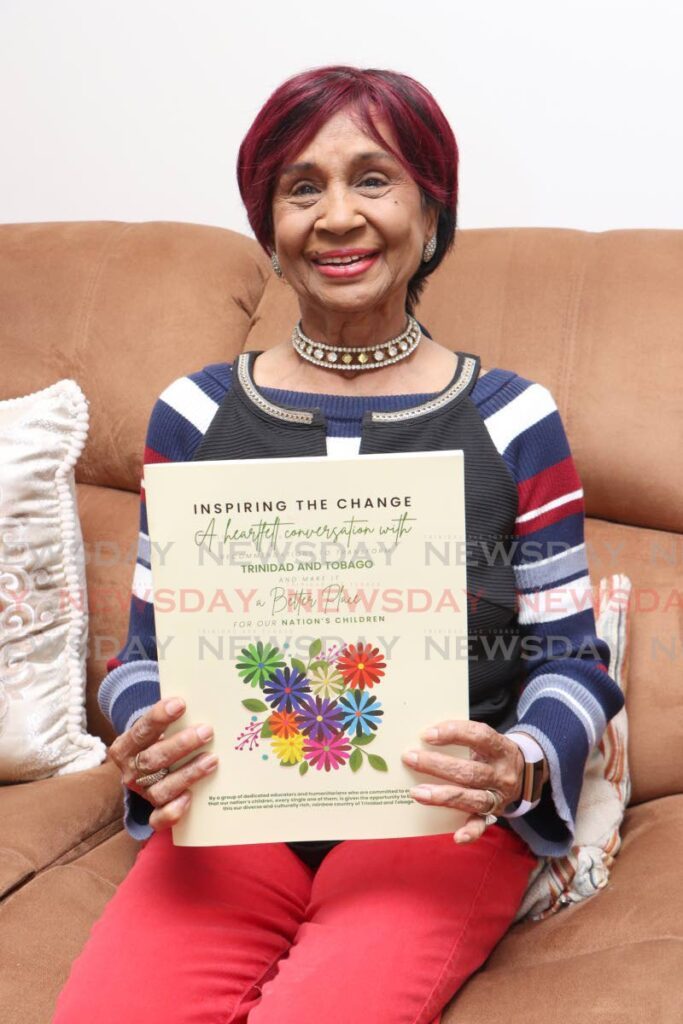 Feroza Mohammed holds up a copy of Inspiring the Change. - Photo by Angelo Marcelle