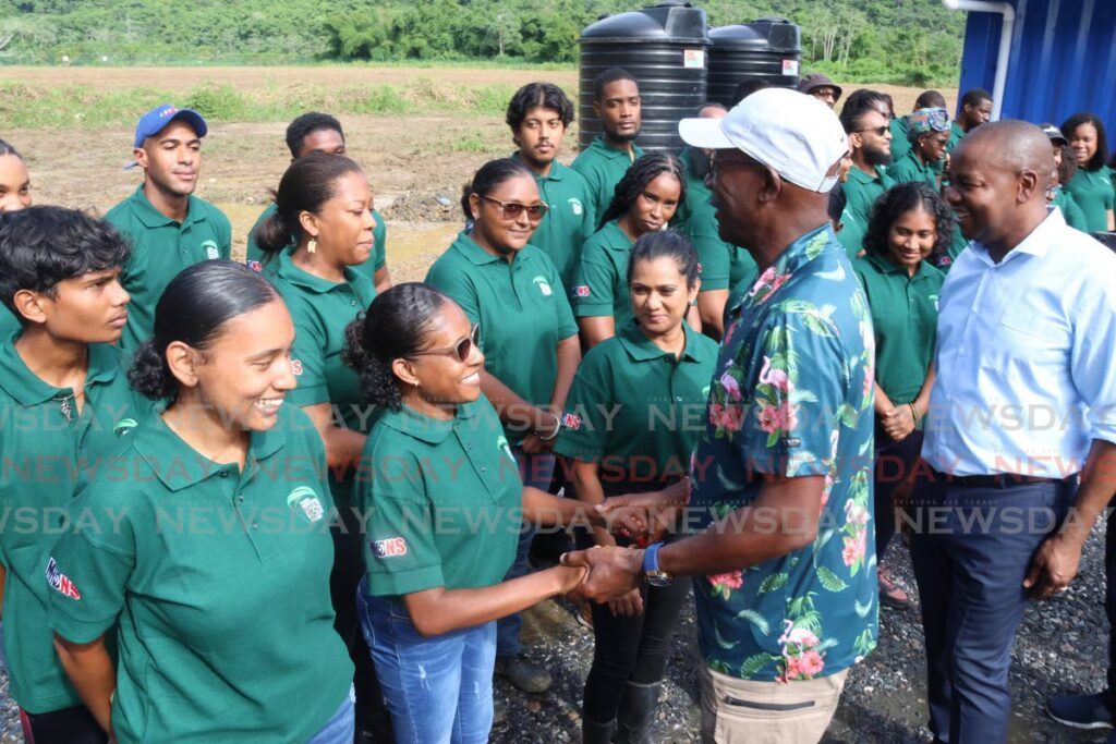 Prime Minister Keith Rowley and Ministry of Youth Development and National Service Foster Cummings greet participants of the Tucker Valley Shade House Project in Chaguaramas on August 15. -  Photo by Roger Jacob 