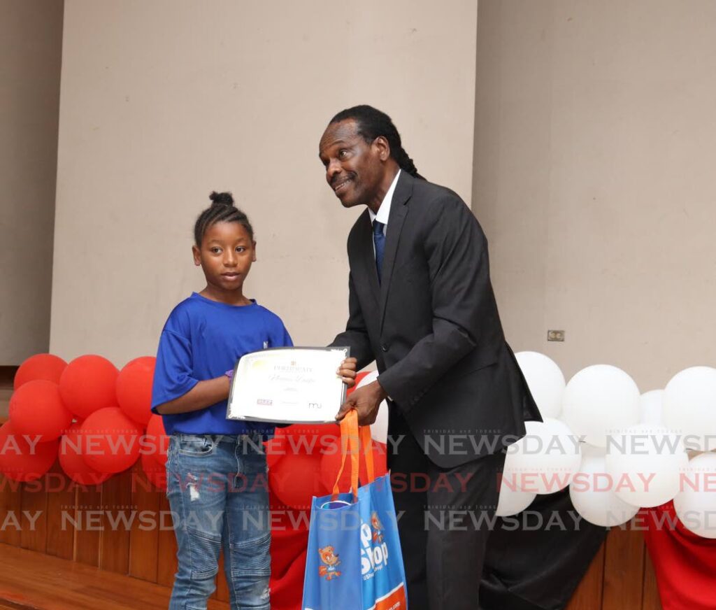 Minister of National Security Fitzgerald Hinds congratulates Naomi Duke. - Photo by Gabriel Williams