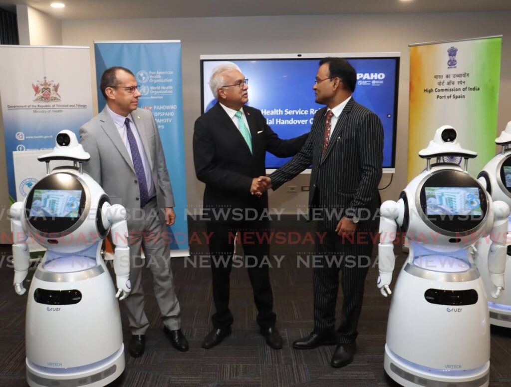 Health Minister Terrence Deyalsingh, centre, shakes hands with Dr Pradeep Singh Rajpurodit, High Commissioner of India, at the official handover ceremony of eight health service robots at the ministry, Queen's Park East, Port of Spain on August 17. Looking on is Gabriel Vivas Francesconi, PAHO representative of TT and the Dutch Caribbean Islands. - Photo by Faith Ayoung