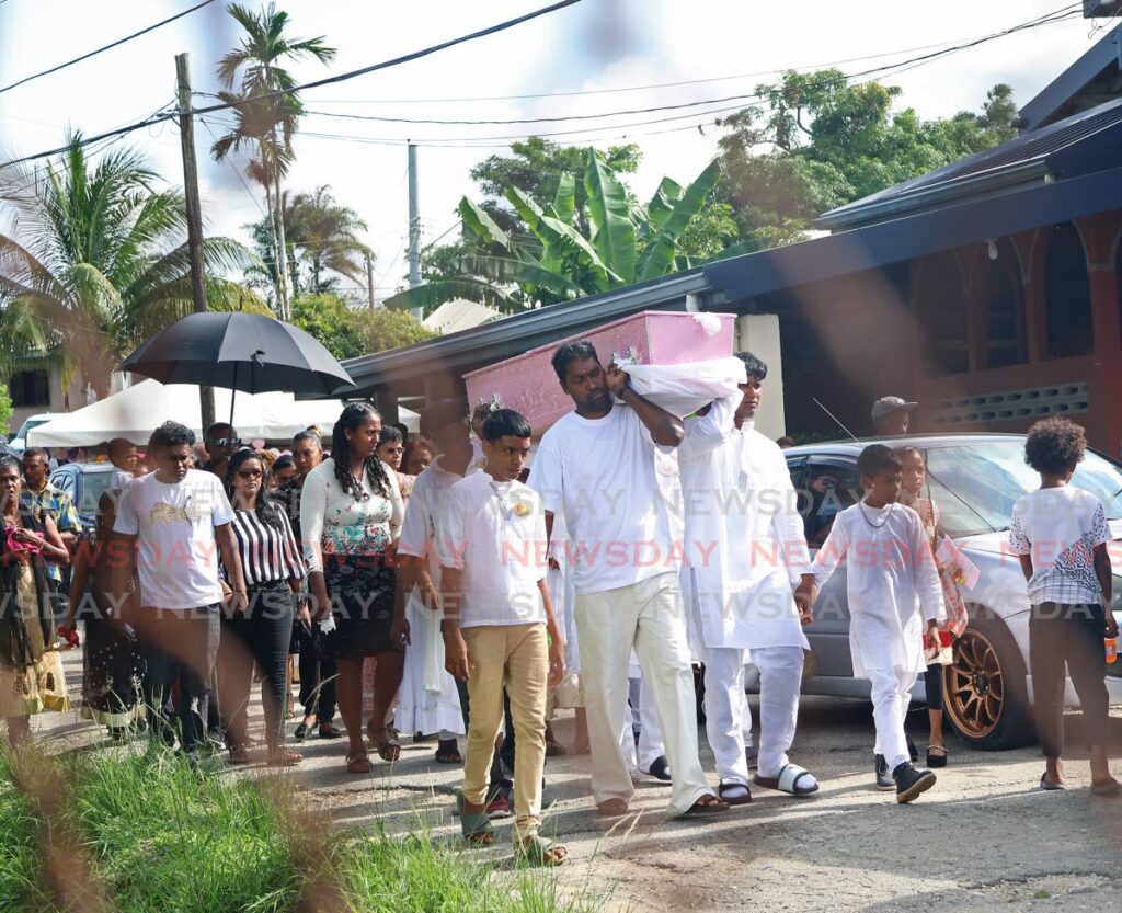 FINAL RITES: Relatives carry the casket bearing the body of eight-year-old Nelisha Narine from her North Trace, New Grant home on August 18.  - Photo by Venessa Mohammed