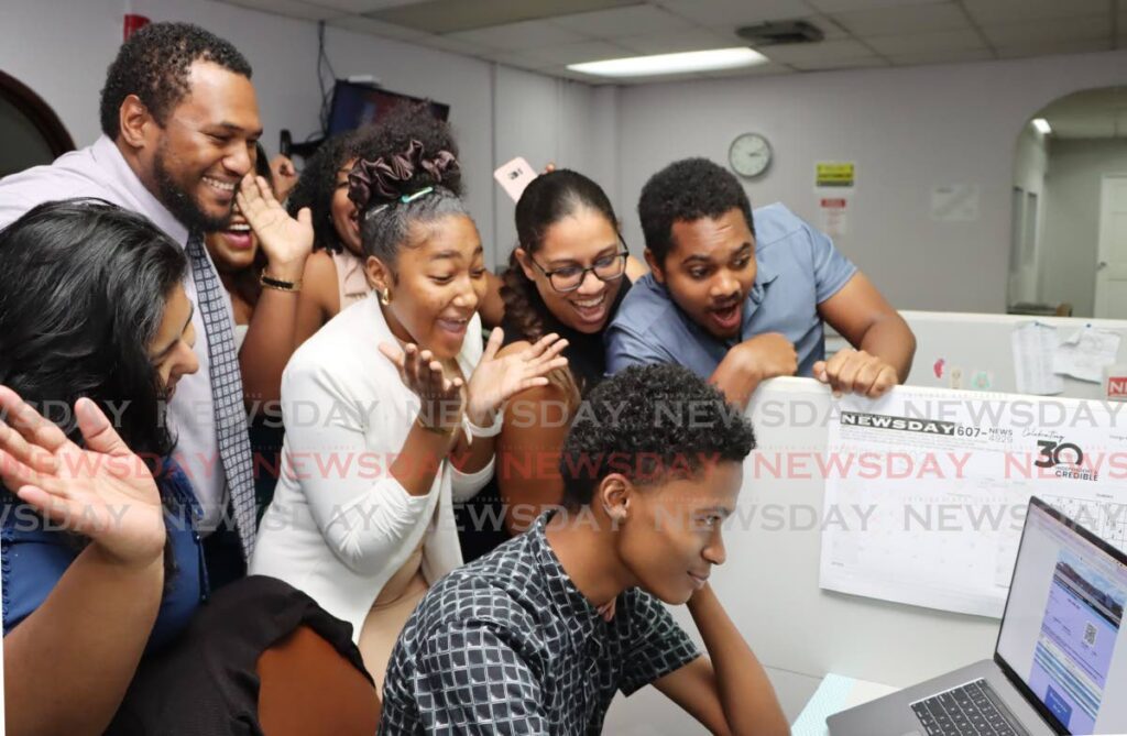 THREE CHEERS FOR GABRIEL: Newsday intern Gabriel Williams is cheered on by his colleagues as he checks his CXC results online at Newsday's Pembroke Street office on August 20.   - Photo by Ayanna Kinsale 