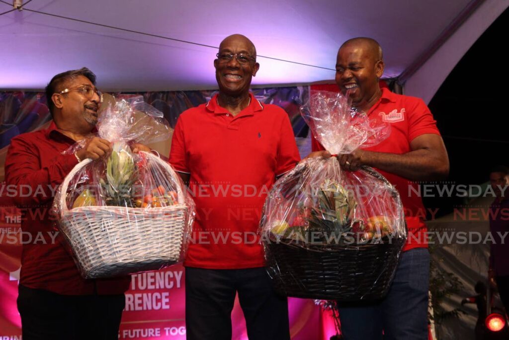 FROM LA HORQUETTA WITH LOVE: Prime Minister Dr Keith Rowley is presented with two hampers after the PNM's La Horquetta/Talparo 10th constituency conference on August 20 by Lennox Rattansingh, the party's constituency chairman for La Horquetta and La Horquetta/Talparo MP Foster Cummings. - Photo by Angelo Marcelle