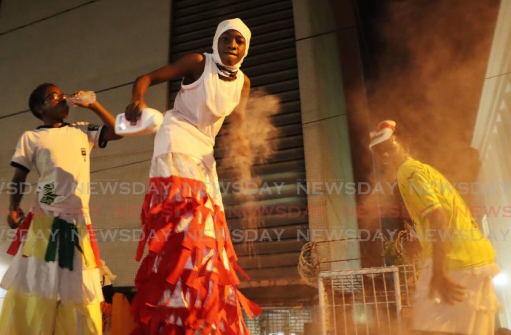 From left, Logan Davis, Jeydon James and Jonathan Smith partake in the Pan and Powder Parade at City Hall on Pembroke Street, Port of Spain.