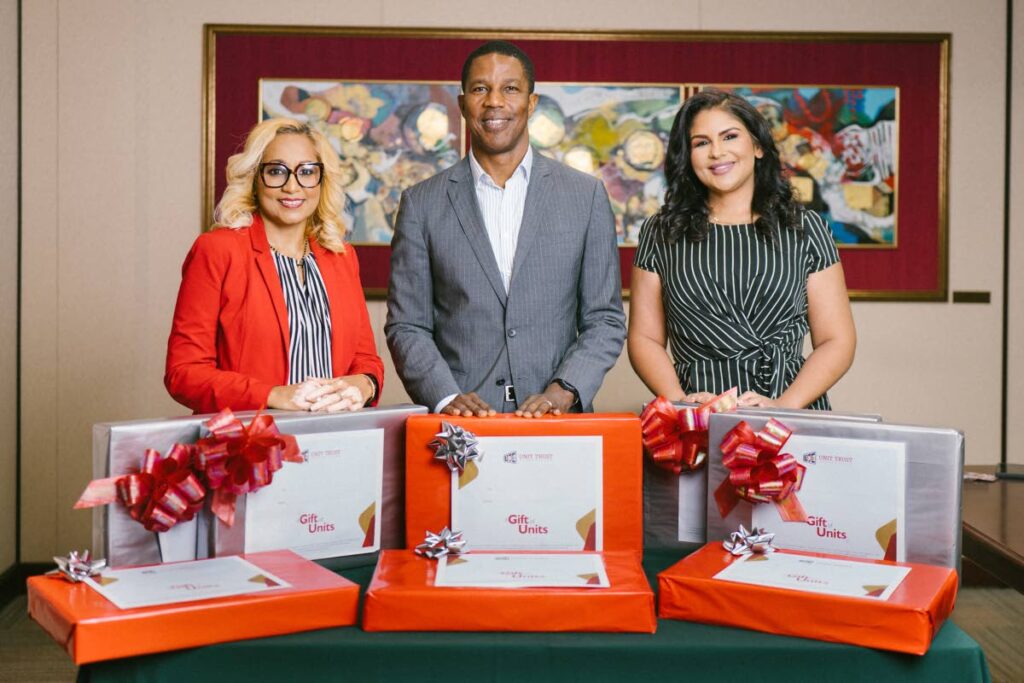 UTC'S GIFTS OF UNITS: Shoba Ganess, brand development manager, left, Nigel Edwards, executive director and Hema Ramkissoon, head of marketing, showcase the laptops, vouchers and 