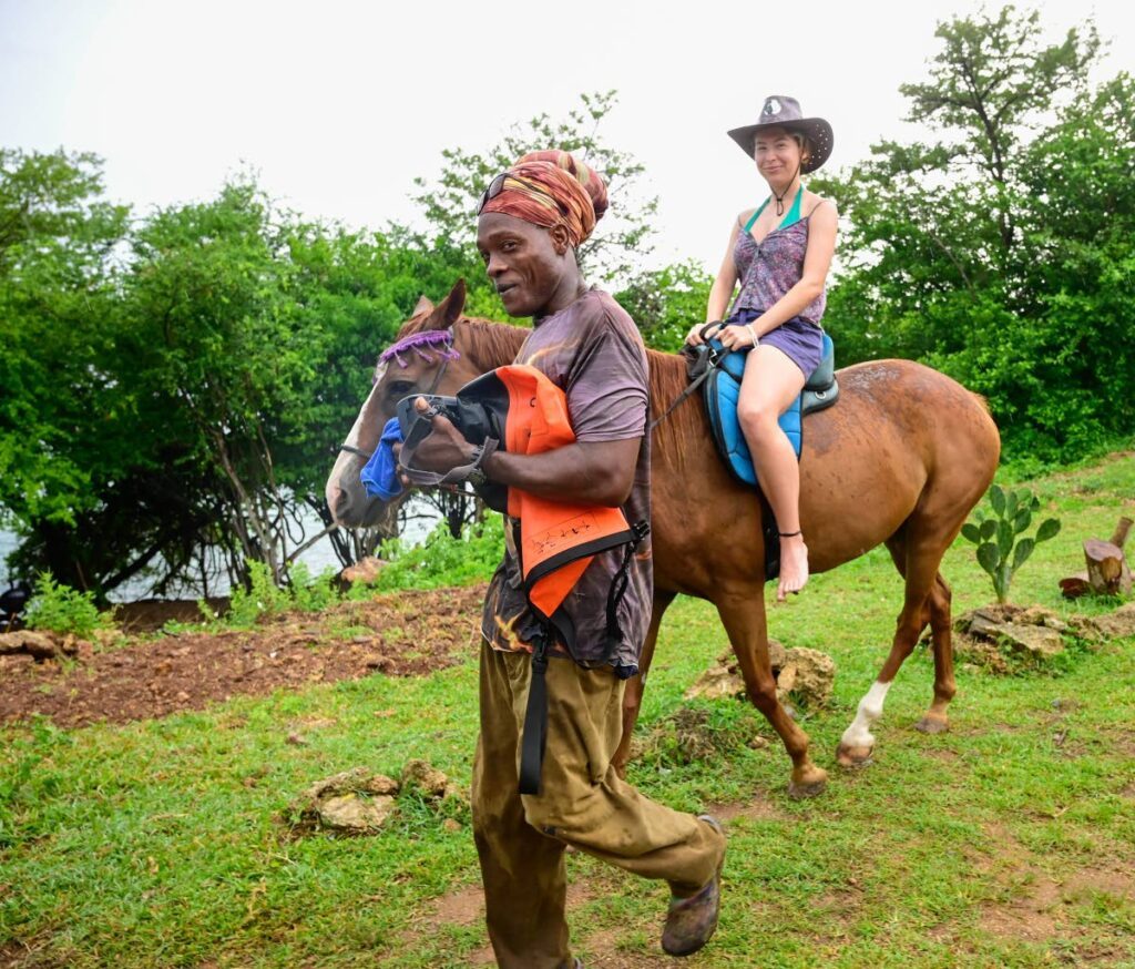 A guide takes a rider on the trail. Healing With Horses turns 14 on August 26. - 