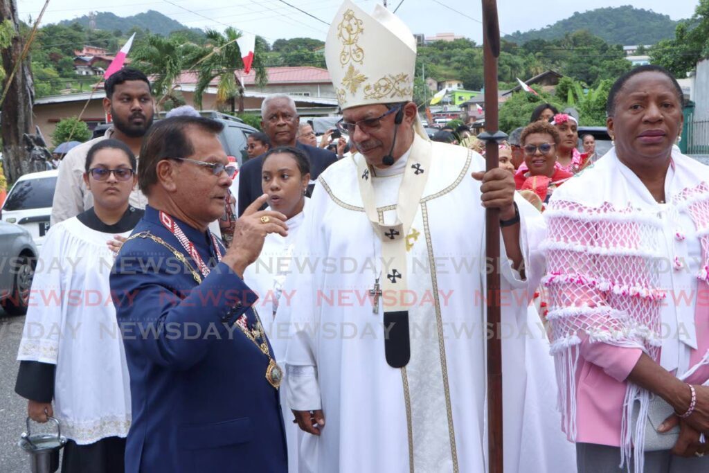 Arima Mayor Balliram Maharaj speaks with Archbishop Jason Charles Gordon, during the Festival of Santa Rosa procession, Woodford Street, Arima on Sunday. On right is Arima MP Pennelope Beckles-Robinson. - Angelo Marcelle