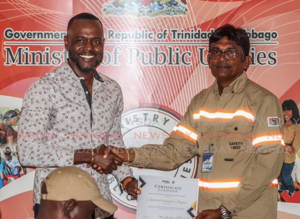 Minister of Public Utilities Marvin Gonzales presents a certificate to T&TEC senior supervisor  Chabindranand Jagdeo in recognition of Hurricane Beryl relief efforts during a ceremony at the Ministry of Public Utilities, Alexander Street, Port of Spain on August 26. - Photo by Gabriel Williams