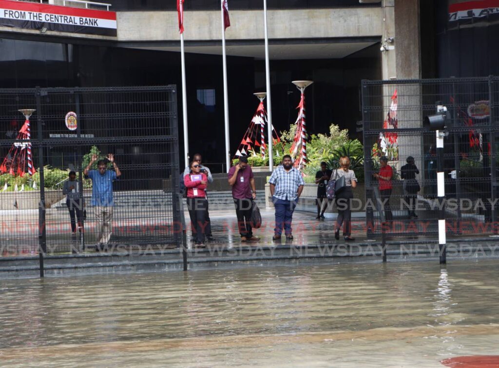 Persons left stranded at the premises of the Central Bank, after midday flash flooding in Port of Spain on August 28. - Photo by Angelo Marcelle