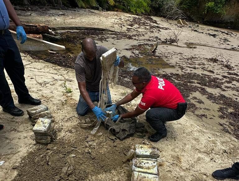 Police officers gather packages of cocaine which were found near a BP facility in Guayaguayare in August 2023. - Photo courtesy TTPS 