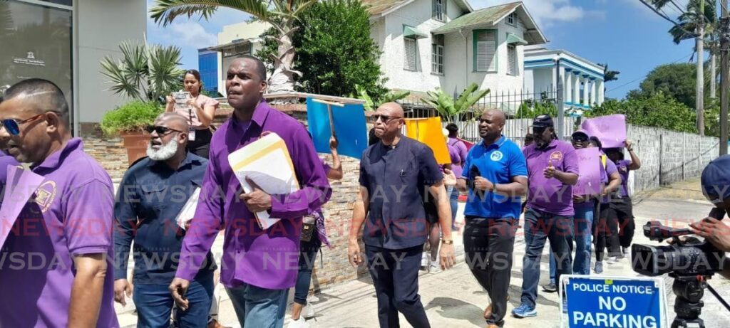 TT Postal Workers Union head David Forbes, along with JTUM officers Ozzi Warwick and Ancel Roget, marched down Alexandra Street, Port of Spain on February 26.  - Photo by Joey Bartlett