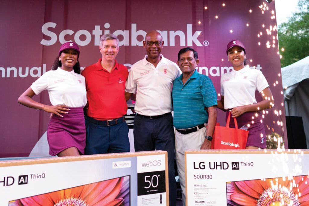 Derek Hudson, centre, chairman of Scotiabank stands with Team Music Radio 97 players Takoor Ramnath and David Campbell who placed second at the 22nd Scotiabank Charity Golf tournament. - 