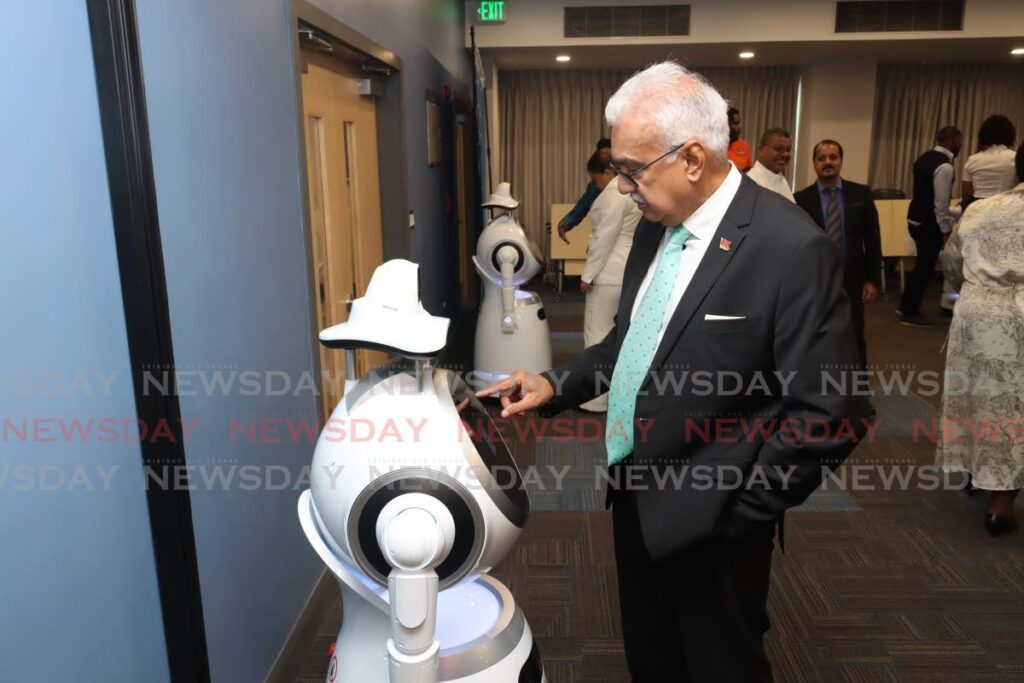 ROBOTIC SURVEY: Health Minister Terrence Deyalsingh fills out a survey on the screen of a robot during a handover ceremony of robotic machines at the ministry's Queen's Park East, Port of Spain office on August 17. - File photo by Faith Ayoung