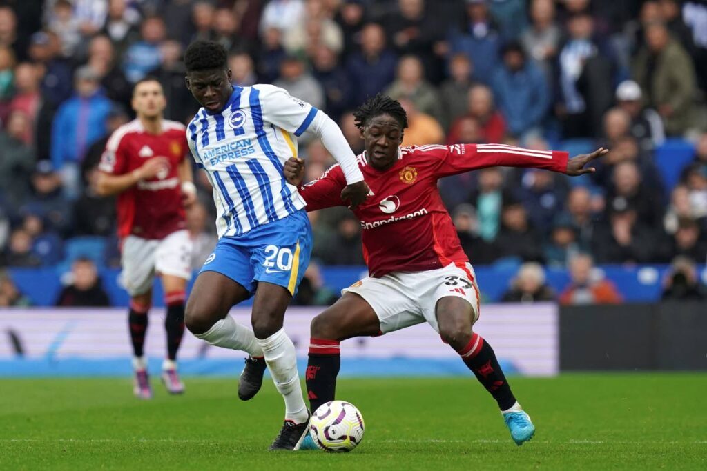 Brighton & Hove Albion's Carlos Baleba, left, and Manchester United's Kobbie Mainoo battle for the ball during the English Premier League match at the American Express Stadium in Brighton, England on August 24, 2024.  - 