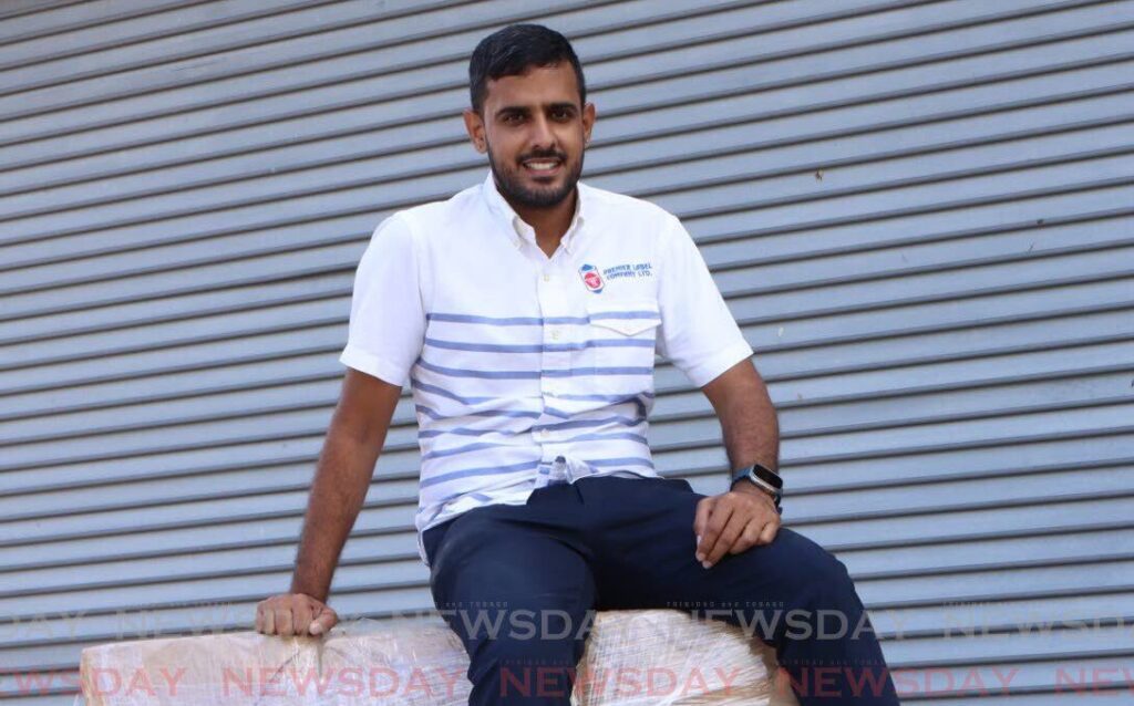 Premier Label owner Varun Maharaj sits on a stack of labels ready for shipment at his San Fernando headquarters.  - Photo by Angelo Marcelle