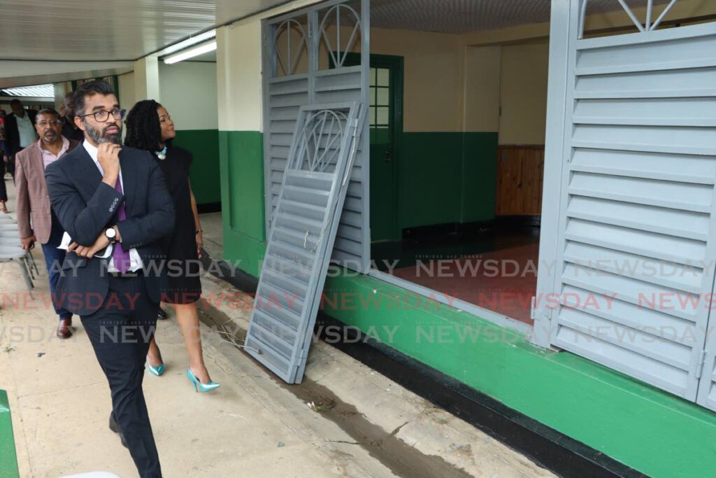 Minister of Education Dr  Nyan Gadsby-Dolly, right, observes a broken window at the auditorium of St George’s College in Barataria, as she takes a tour of the school on August 30. San Juan/ Barataria MP Saddam Hosein is on the left. - File photo by Angelo Marcelle