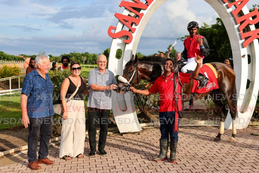 SWEET VICTORY: Hello World, with jockey Dillon Khelawan, was escorted to the winner's stage by owner Neil Poon Tip, third from left, trainer John O'Brien, left, and Kristin Chiselko of the Poon Tip Stud Farm, second from left, after winning the Independence Cup race at the Santa Rosa Park on August 31, in Arima.  -  Photo by Daniel Prentice 