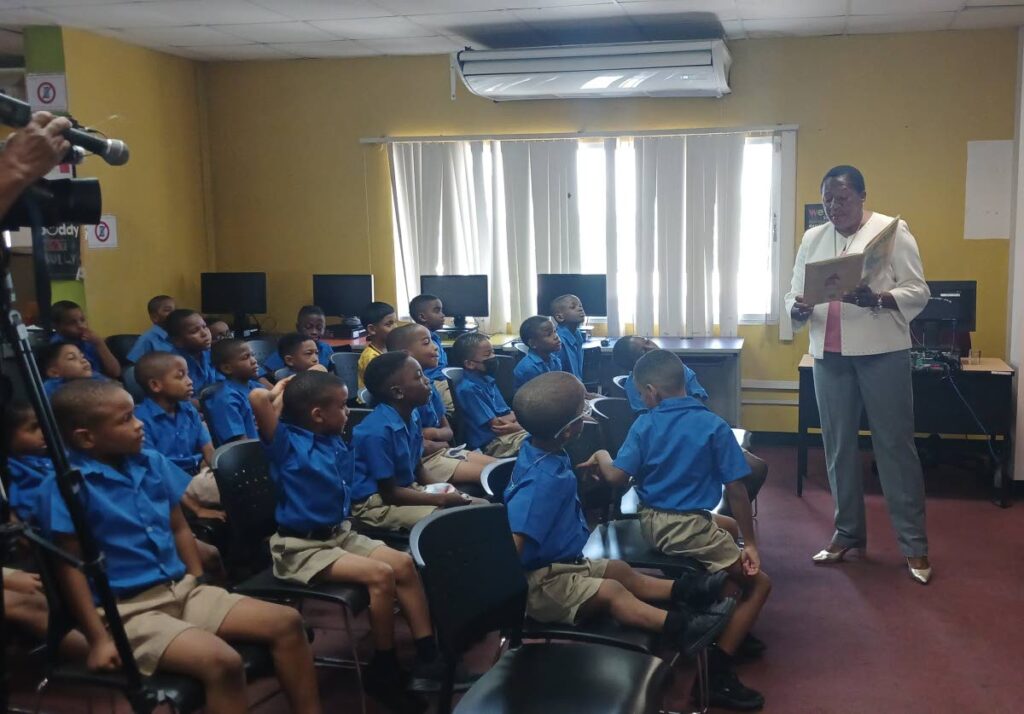 Students of Arima Boys Government School listen as MP for Arima Pennelope Beckles delivers a vibrant reading of Jessica Souhami’s book No Dinner, The Story of the Old Woman and the Pumpkin, at the Arima Public Library on Pro Queen Street, on September 4. - Joey Bartlett