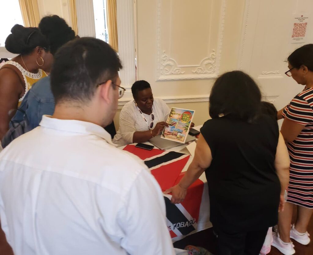 Dr Charmaine Blaize (seated), co-founder of Women of Colour Scotland, highlights the book How it was Back in The Day by Sanja Dharamdass. - 