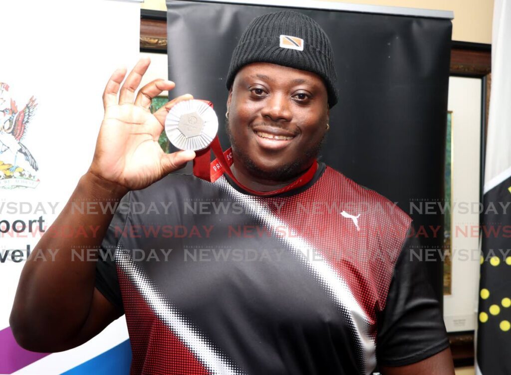 Paralympic Games men’s discuss F64 silver medallist Akeem Stewart shows off his medal after his return to Piarco International Airport, Piarco on September 10. 