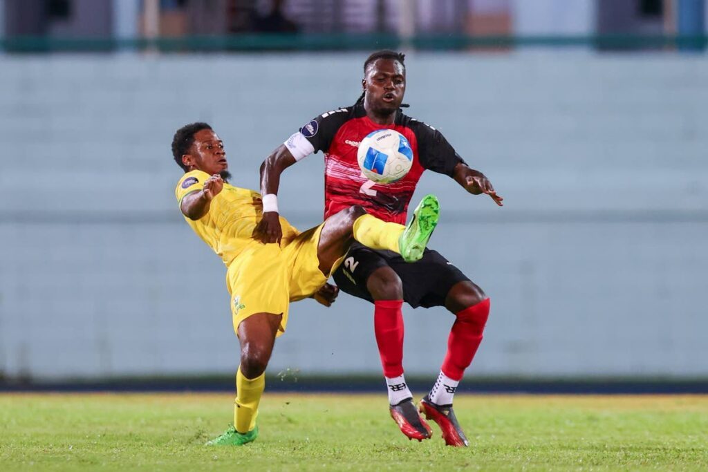 TT captain Aubrey David (R) vies for control of the ball against French Guiana during a Nations League match, on September 10, at the Dwight Yorke Stadium, Bacolet, Tobago.  - Photo by Daniel Prentice