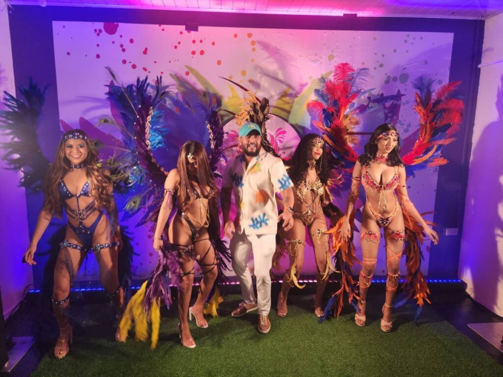 Chutney soca artiste and CIP Mas band leader GI takes a jump with models at the launch of the band's 2025 Carnival presentations. - Yvonne Webb