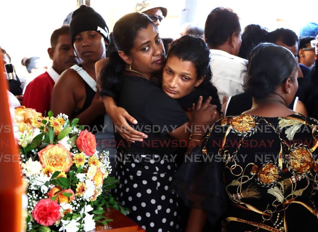 Sherese Singh is consoled by a relative during the funeral for her siblings Keston and Shenelle Singh at Lewis and Sucre Street, Mayaro, on September 13. - Photo by Ayanna Kinsale 