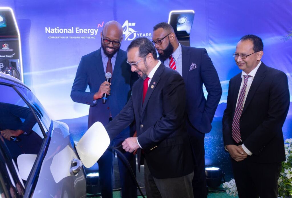 Energy Minister Stuart Young demonstrates the use of the EV charger installed at Queen's Hall, Port of Spain. Looking on are National Energy representatives, Dr. Vernon Paltoo, Dr. Joseph Khan, and Arden Rodriguez. - Courtesy National Energy/ Ministry of Energy