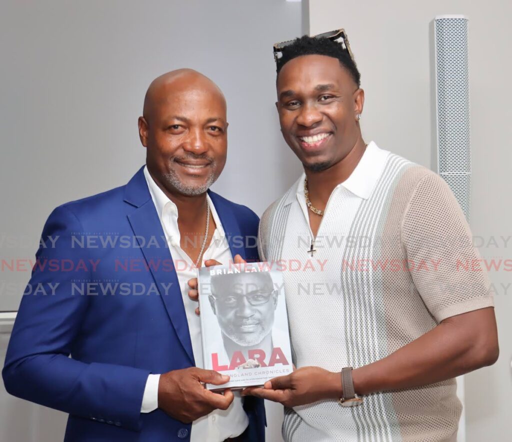 West Indies cricket legend Brian Lara, left, displays a copy of his book Lara: The England Chronicles alongside Trinbago Knight Riders’ Dwayne Bravo during a launch on September 17 at Lara’s residence, located at Lady Chancellor Hill, Port of Spain. - Photo by Faith Ayoung