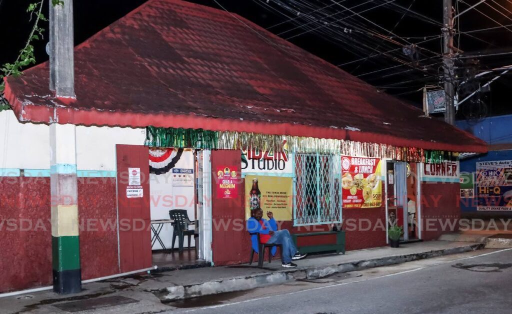 A man sits in front of Nyabinghi Bar where Health Minister Terrence Deyalsingh got robbed in St Joseph on September 17. - File photo by Angelo Marcelle