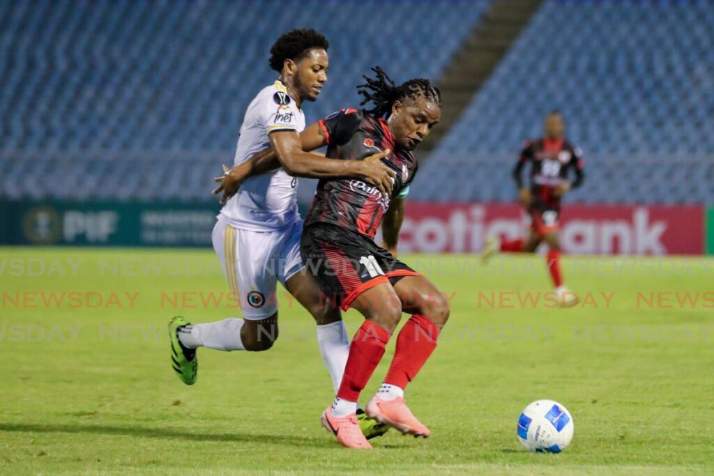  Daune Muckette (L), of AC Port of Spain, holds off Sherman Augustin, of Grenades FC, during the 2024 Concacaf Caribbean Cup match at the Hasely Crawford Stadium on September 17, in Port of Spain. - Photo by Daniel Prentice