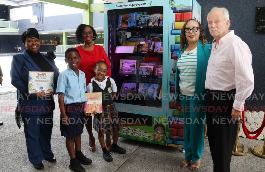 Melvyn Chavkin and his wife Erica donated a book vending machine to the San Juan Government Primary School through the Adopt-A-School Programme, in collaboration with the Ministry of Education on September 19. The couple posed for a photo with students Mathias Williams and Curleah Mirgoo and principals Shirley Jaggasar-Villafana and Donna Thomas-Sealy. - Photo by Roger Jacob