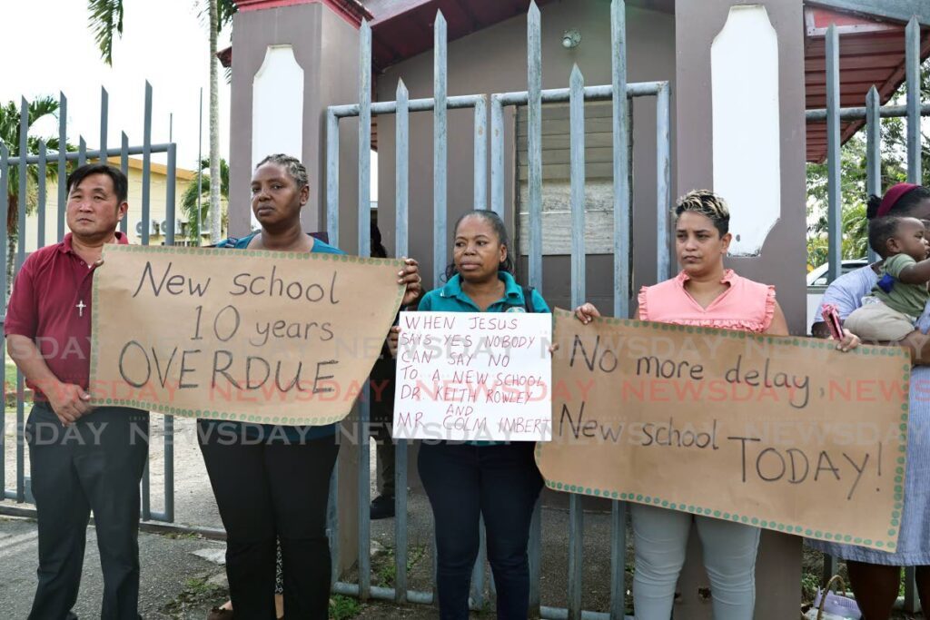 Frustrated members of the Parent Teacher Council of St Dominic's Penal RC School protest outside the school compound on September 19. TTUTA President, Martin Lum Kin, left, stands with parents as they plead with the government to provide a new school for their children. - Photo by Venessa Mohammed