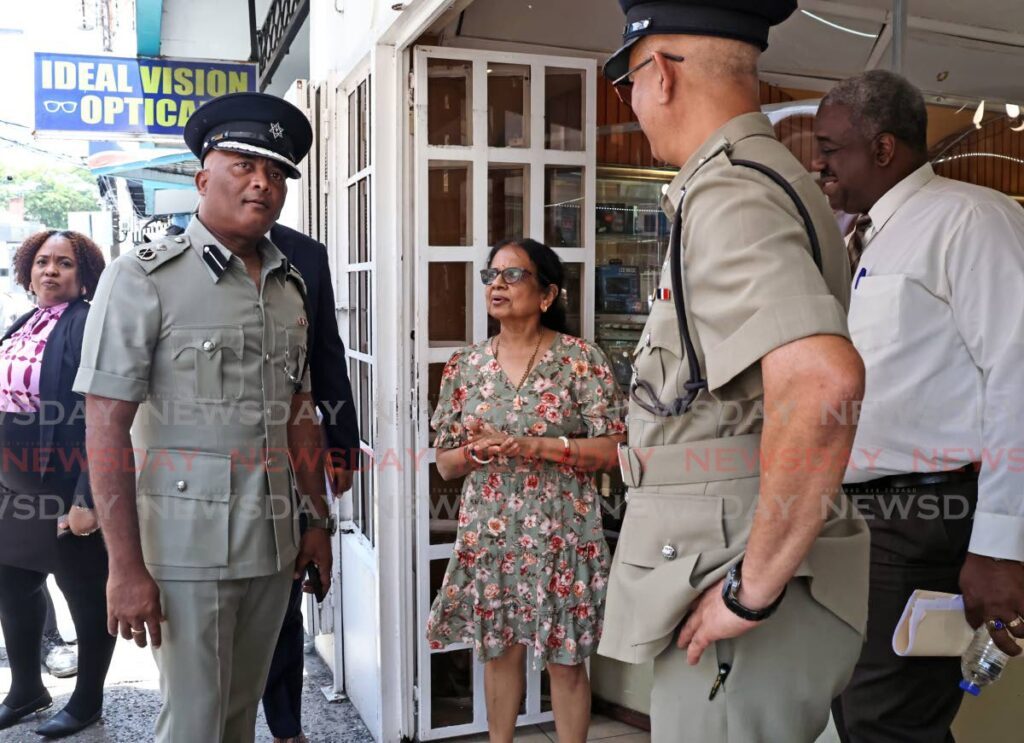 Owner of Laxmi Jewellers Ltd, Laxmi Patel, centre, speaks with ACP (southern/central region) Wayne Mystar, left. - venessa mohammed