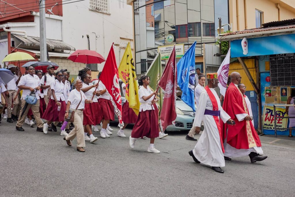 Anglican Bishop Rev Claude Berkley leads the procession from St Andrew’s Parish Church into Scarborough to mark the launch of Bishop’s High School centennial celebrations on September 13. - Photos courtesy Brettney Romeo 