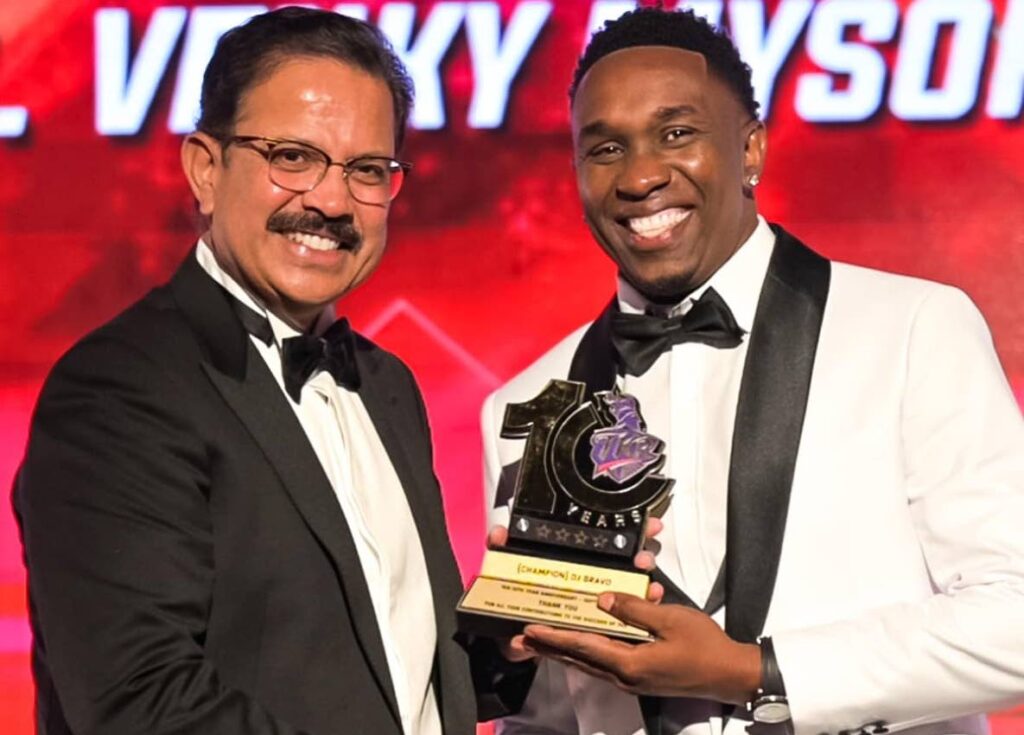 TKR legend Dwayne Bravo, right, collects a trophy from Knight Riders CEO Venky Mysore during a function on September 20 to celebrate a decade of excellence for the team, at Hyatt Regency, Port of Spain. - Photo courtesy Trinbago Knight Riders 